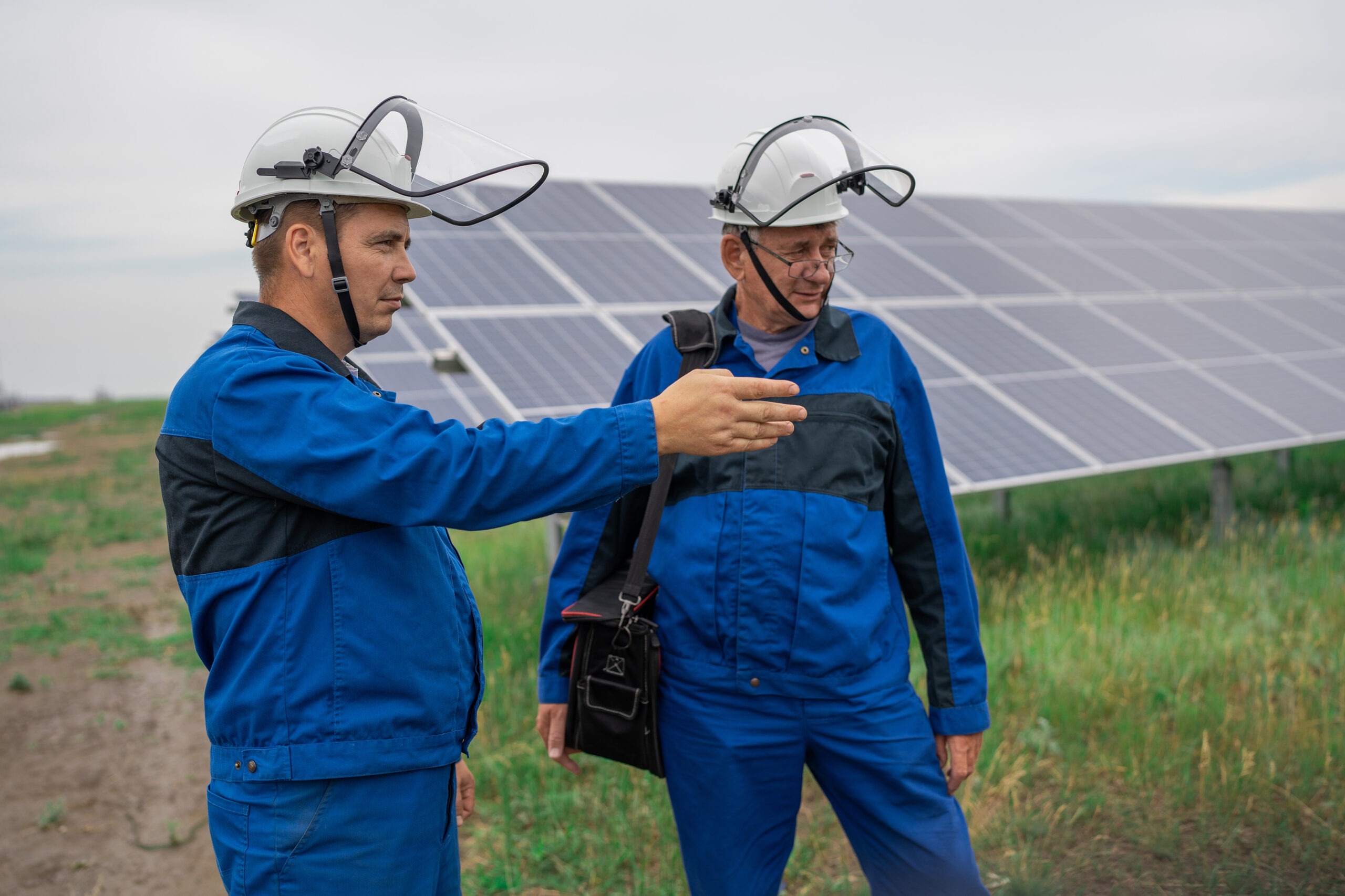 Service Engineer man standing with arms crossed in front of solar panels. Technician maintenance solar cells on Solar Energy Plant under morning sunlight. Technology solar energy renewable revízia fotovoltaiky